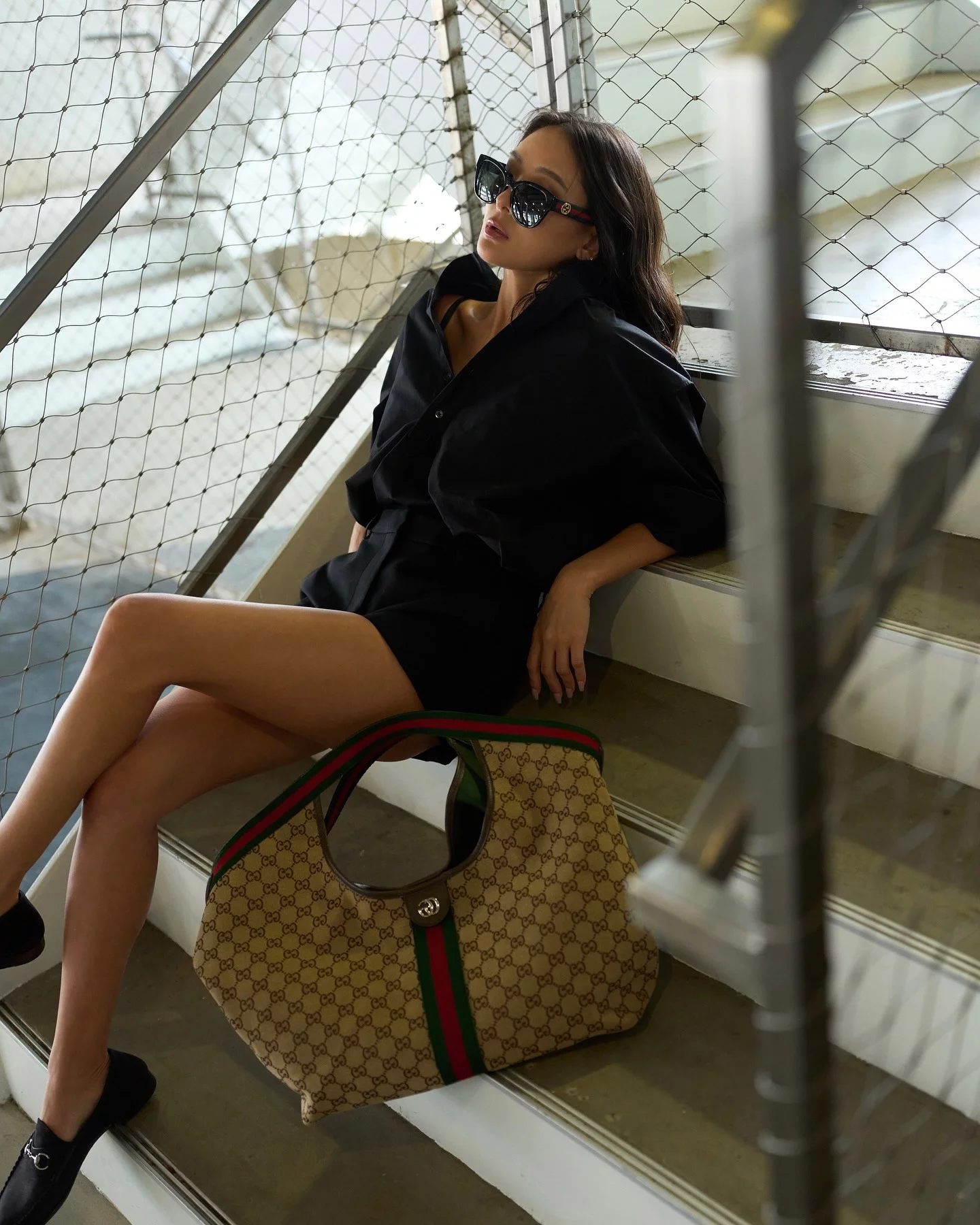 孫芸芸以一件寬鬆黑色襯衫搭配短褲，利用「上寬下短」的比例，不只修飾身形，也讓腿部線條更加修長，襯衫微微敞開領口，帶出隨性感與女人味，配件上選擇經典馬銜鍊樂福鞋，以及造型最大亮點，則是來自Gucci的Giglio卡其色GG帆布大尺寸托特包，張曼玉也曾上手過！