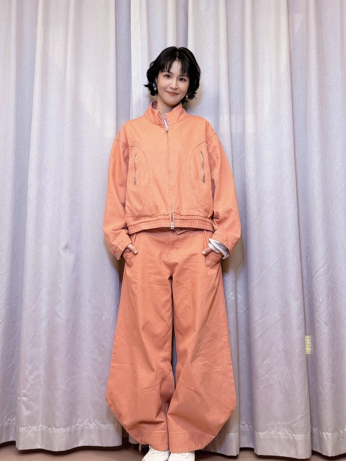 曾沛慈以一套橘色丹寧套裝亮相，來自魏如昀執掌的服裝品牌Retem03，丹寧外套搭配寬版牛仔褲，寬褲輪廓讓整體更輕鬆不拘謹，搭配小白鞋則成功中和丹寧的份量感，整體以橘色系貫穿，自帶提氣色效果，讓膚色看起來更明亮，是女孩子能夠參考的顯白穿搭！