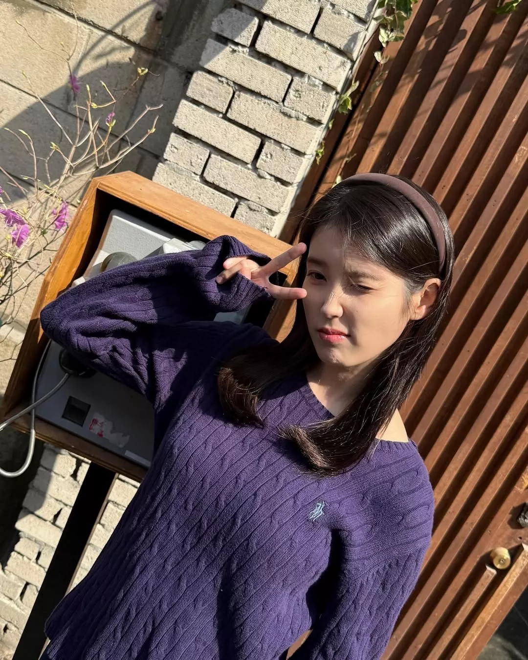 IU選擇偏深、帶點冷感的紫色Ralph Lauren針織,看似不好駕馭,其實對膚色非常友善,尤其在陽光下會把膚色襯得更乾淨,而不是顯黃。