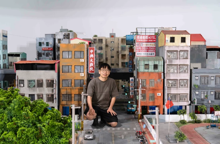 藝術家張立人與《戰鬥之城》城市模型合影。以自身身體為比例尺、依憑記憶空間尺度搭建展場舞台。