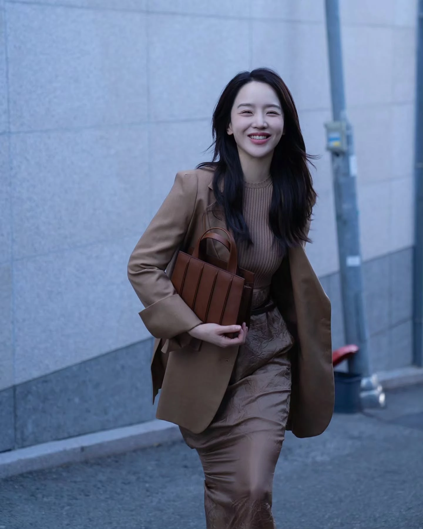 申惠善這套以 Max Mara 駝色西裝外套為核心的私服造型，搭配同色系上衣與裙裝，手提 Max Mara Whitney 包，整體沒有任何強烈對比，卻透過層次與材質，堆疊出一種極為成熟、內斂的氣場。放回到職場穿搭，駝色、奶茶色這類中性色，本身就自帶專業與信任感，特別適合需要長時間溝通、談判或建立關係的工作情境。