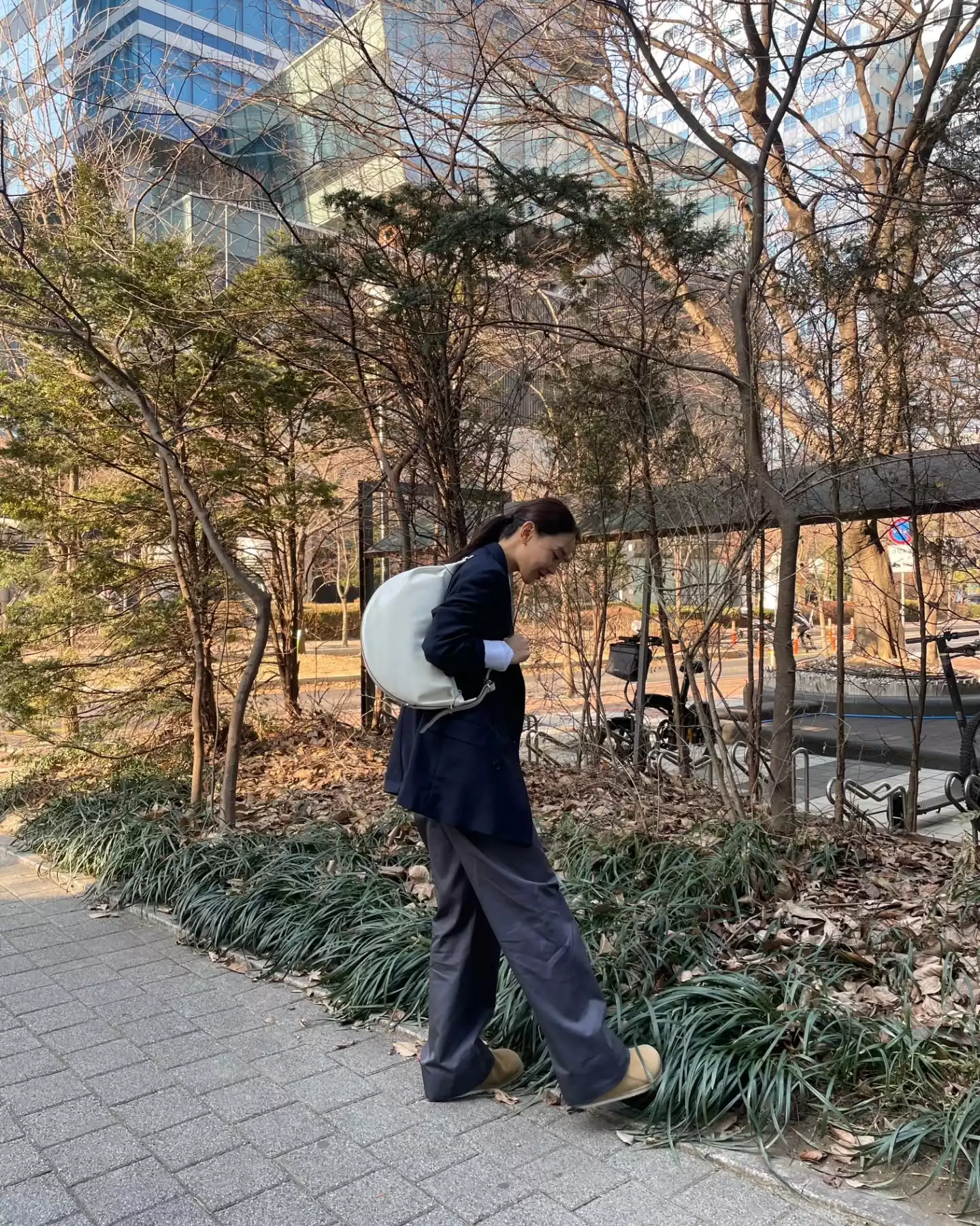 在這套 IG 私服造型中，申惠善選擇深藍色西裝外套搭配寬鬆長褲與大尺寸包款，整體線條俐落、比例放鬆，卻完全不顯隨便，上身西裝結構清楚，下身刻意放寬，視覺重心往下延伸，讓整體更穩。深藍色比黑色更溫和、比灰色更有重量，是最容易建立信任感的專業色系之一。