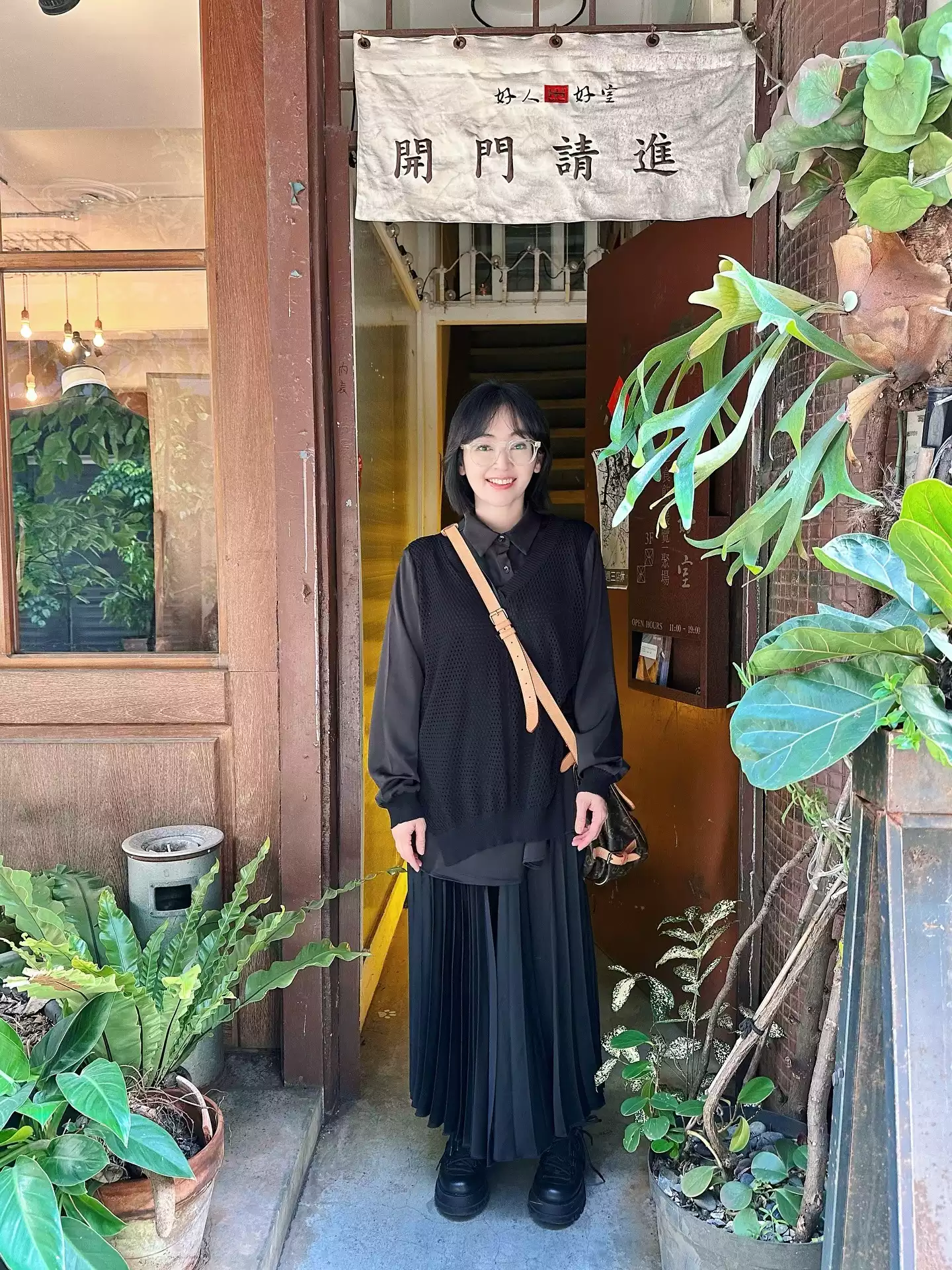蔡燦得以全黑同色系作為基底,內搭襯衫、外加針織背心,再搭配飄逸百褶長裙,透過「多層次堆疊」讓整體看起來更有份量卻不顯厚重。特別是上半身利用襯衫領口與袖口露出細節,打破全黑的沉悶感,也讓造型更有呼吸感與日系氛圍。