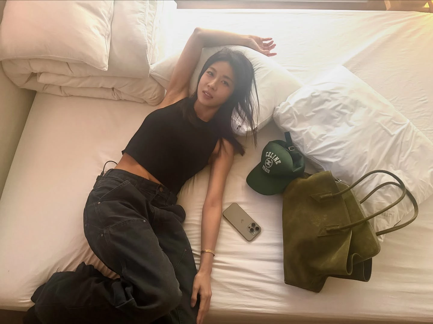 河智苑以黑色短版背心搭配深色牛仔褲，短版剪裁微微露出腰線，不只拉長比例，深色丹寧的選擇，讓整體更顯修身，也更有成熟洗鍊的氛圍，點綴上The Row托特包，看似簡單卻非常耐看！