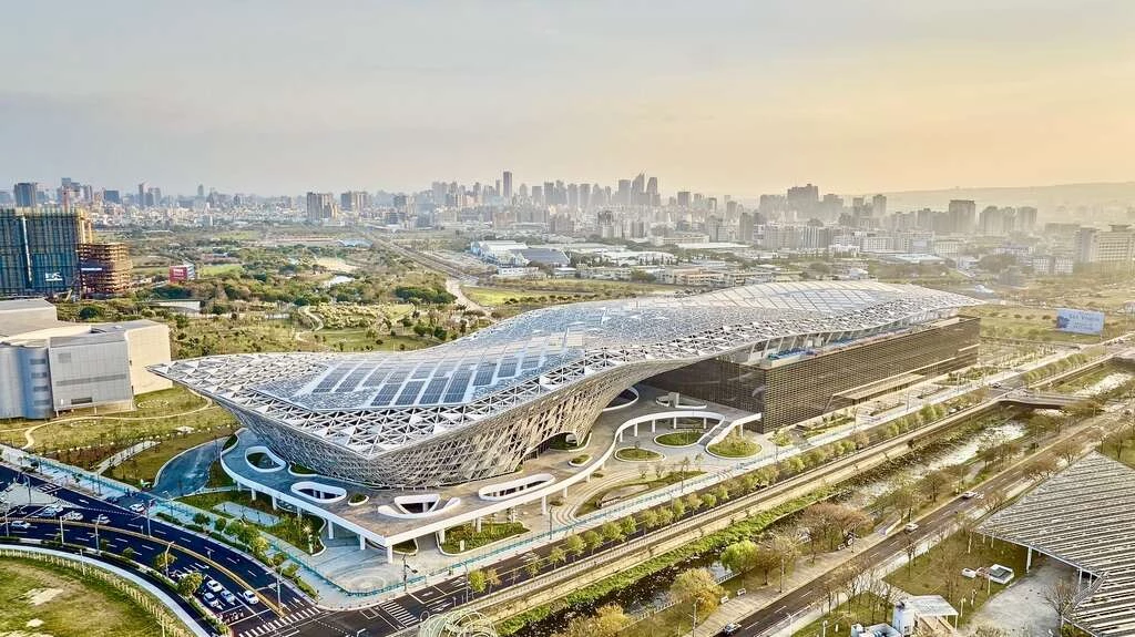位於中央公園旁的台中國際會展中心，以「大樹之門」為設計理念，呈現如草坪上樹枝搖曳的大樹意象，屋頂象徵茂密樹枝的層層變化，讓陽光透過樹隙灑落，形成斑駁光影。建築擁有全台最複雜的曲面屋頂之一，也是國內使用空間桁架最多的會展中心，形塑出簡潔優雅的天際線，宛如一張巨型魔毯。未來全年預計舉辦 52 檔展覽、30 場大型活動及265 場會議，可望創造逾億元商機。