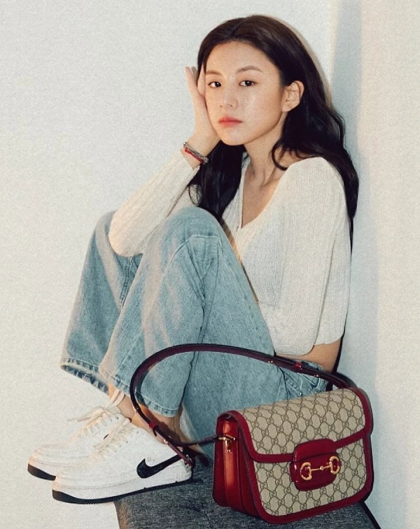 高允貞的私服，之所以成為許多現在Gen Z世代們心中的穿搭範本，關鍵就在於她總能把看似平凡的日常單品，透過俐落剪裁與細節選擇，轉化成帶有質感的時髦造型。無論是以短版針織上衣微微露出腰線，或將上衣紮進高腰寬褲，都能自然拉長身形比例，營造出輕盈又修長的視覺效果。同時，她也經常透過「異材質混搭」為造型加分，像是用休閒感十足的外套或白T，搭配精品包款，巧妙平衡隨性與精緻之間的界線，讓整體看起來不會過於用力，卻依然充滿層次。