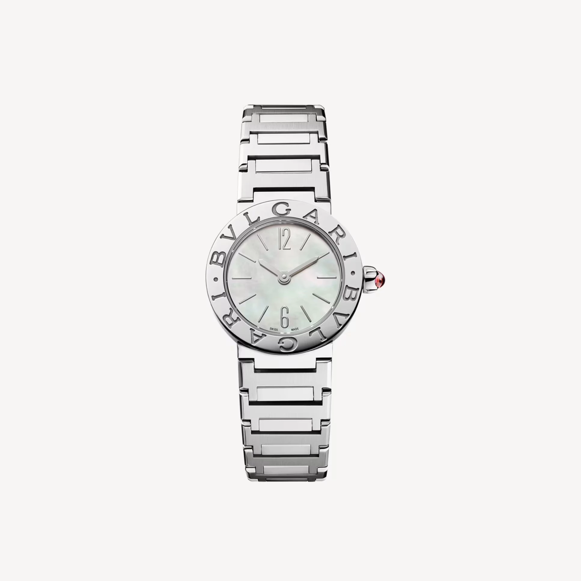 寶格麗在1977年推出 Bvlgari Bvlgari 腕錶時，做了一件相當大膽的事：直接將品牌名稱刻在錶圈上。靈感來自古羅馬錢幣的環形鐫文，這樣的設計不只是裝飾，更像是一種宣告。23毫米錶徑搭配珍珠母貝錶盤，在光線下呈現柔和變化，與精鋼錶殼形成剛柔對比。蛋面型切割紅碧璽錶冠則像一個小小的點睛細節，讓整體更有層次。這款腕錶適合那些對風格有明確主張的女性，它不追隨流行，而是用一種帶有文化背景的設計語言，穩穩地站在自己的位置上。