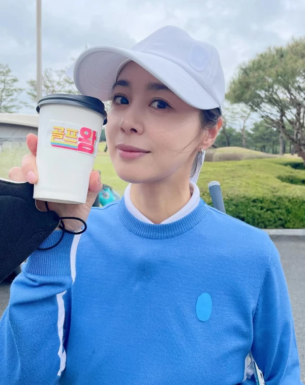 看到這張徐令姬在戶外球場的自拍照角度，還真有點像港星關之琳啊〜我真的被她的狀態給美到了！一件飽和度高、極具朝氣的天空藍圓領針織衫，內搭白色小立領製造層次，頭上則配戴一頂白色棒球帽。沒有多餘的彩妝和華麗首飾，這種「藍 + 白」的乾淨配色，在陽光下就像一劑天然的視覺防腐劑，整個人散發出一股無雜質的減齡感，誰能相信她47歲了？