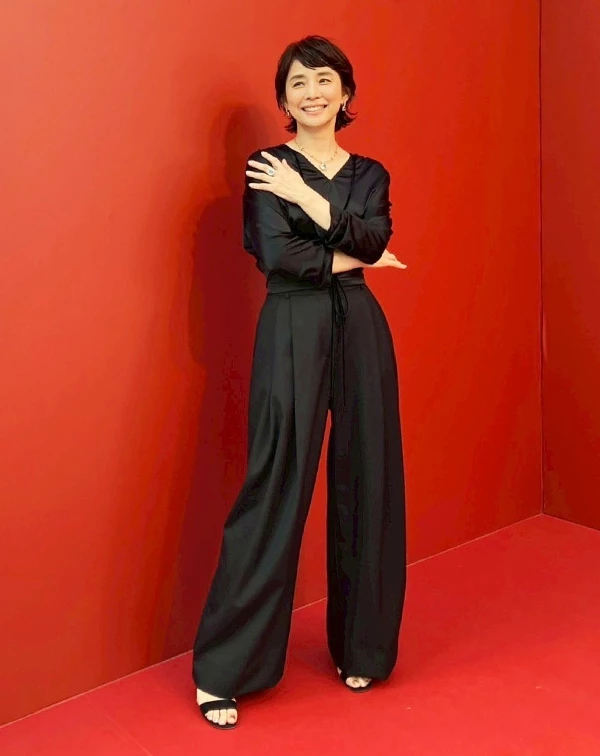 石田百合子展現了熟齡女性最極致的「優雅力量感」！俐落的V領剪裁，不僅延伸了頸部線條，讓整個人看起來更加修長，成功擺脫了全黑造型容易有的沉重感。而既然，她是參加珠寶活動，簡單配戴具存在感的戒指與項鍊，便可讓造型視覺有個重點聚焦，高級感瞬間滿點。