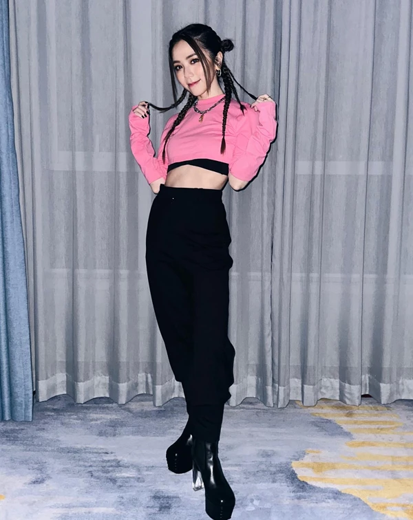 極具鄧紫棋個人標誌性的「甜辣龐克風」。大膽運用高飽和度的芭比粉短版衛衣，在視覺上瞬間奪取視線，並透過「極短與極黑」的強烈對比，精準演繹小隻女如何穿出超強氣場。