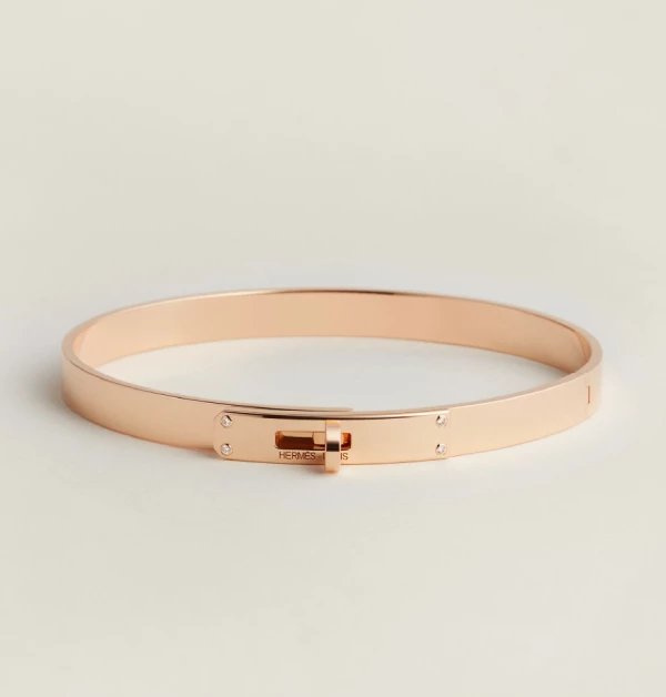 「Kelly」手環以玫瑰金打造，靈感承襲Hermès（愛馬仕）經典「Kelly」包的標誌性旋轉扣環設計，將皮件語彙轉化為俐落優雅的珠寶線條。簡潔流暢的圓弧輪廓結合精緻金屬細節，在低調之中展現高度辨識度，將日常配件昇華為精緻且雋永的設計之作。（商品價格約：NTD 320,300）