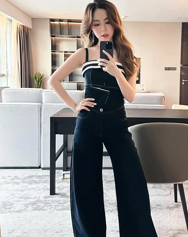 鄧紫棋捨棄了繁瑣的層次，轉而利用一套深色連身裝，將視覺拉長到了極致。統一色塊，是小隻女的救星。這件連身褲從肩帶延伸至地面，完全模糊了真實的腰胯位置，