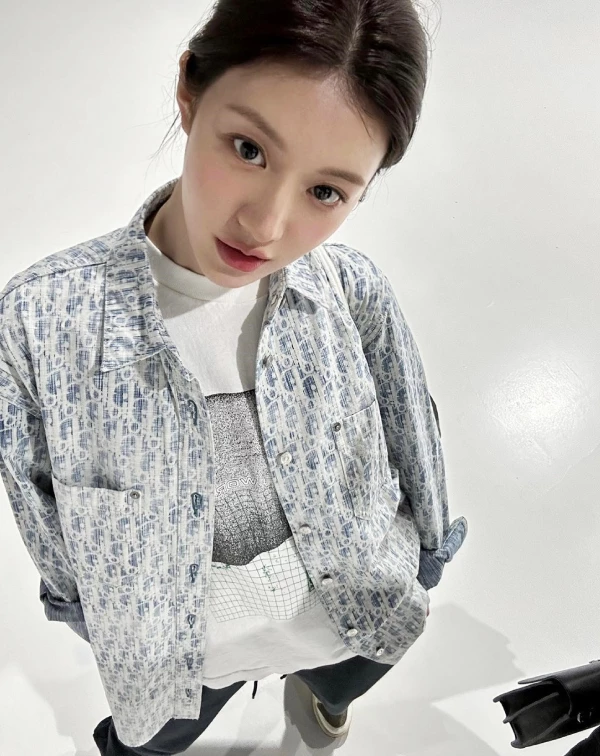 高允貞完美將「滿版Logo」穿得高級而不俗氣。她聰明地選擇清爽的藍白配色 Dior老花牛仔夾克，內搭一件帶有圖騰的白T，利用顏色呼應打造層次感，並將袖口隨性捲起。下半身，則是保持簡潔，並以深色長褲與經典球鞋收尾。這樣的搭配層次正是她最擅長的「Clean Fit 穿搭美學」，即便滿身名牌，也能穿出鄰家女孩的隨性氛圍。
