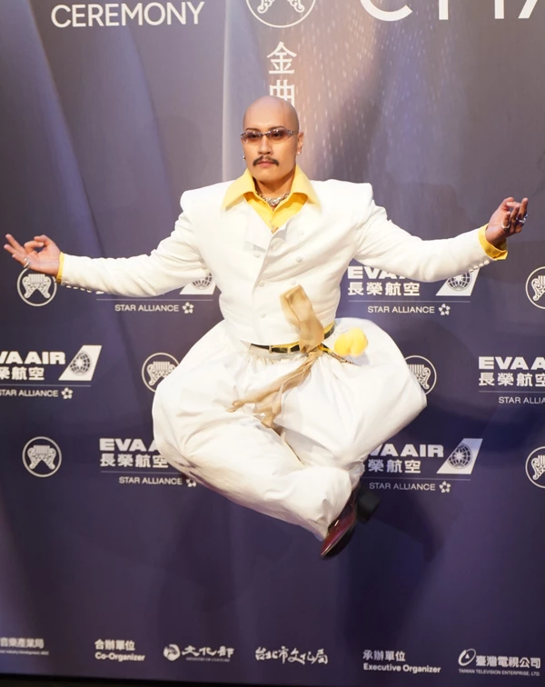 相較於許多藝人選擇穩健安全的正式禮服,黃宣這套造型真正吸引人的並非設計本身,而是他把整體穿搭變成一場完整的表演。從服裝配色、姿態到神情,每一個細節都展現鮮明的個人特色,令人印象深刻的紅毯態度。