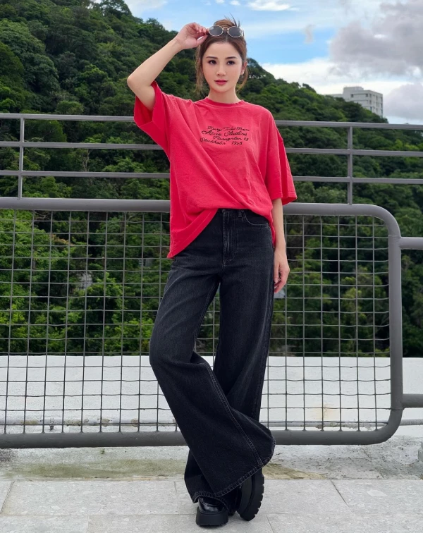阿Sa以一件亮紅色Oversized字母T，搭配黑色高腰丹寧褲與厚底鞋，透過「上亮、下暗」的比例，成功壓住了紅色的張揚，讓整體穿搭在隨性中保有酷感俐落。頭頂上隨意推上的墨鏡，更是畫龍點睛，為這身休閒打扮增添了幾分俏皮的時髦態度。