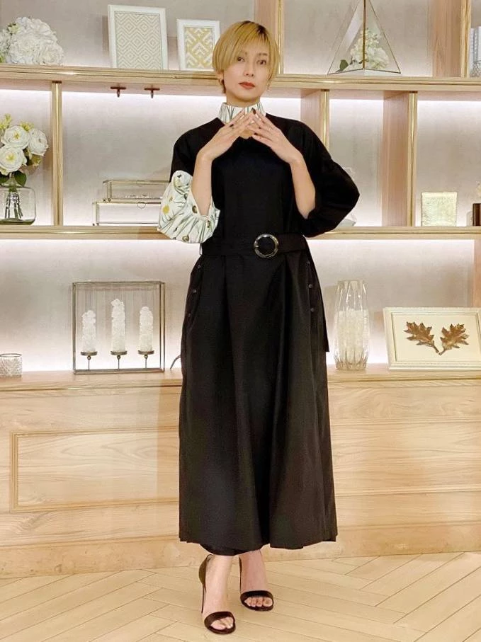 熟齡女性在穿著大面積黑色時,如果不想露膚,可以透過「局部淺色圖騰提亮」。不需要買一整件花哨的衣服,卻可以選擇領口、袖口有異材質拼貼的款式。或者,更簡單的實操方法,在穿著素色黑洋裝時,在領口綁一條真絲小方巾,露出高雅的圖騰,就能達到一模一樣的提亮與減齡效果!最後,搭配一雙露出腳背的細帶涼鞋或尖頭穆勒鞋,保持腳踝的空氣感,整個人就會看起來輕盈又有品味。