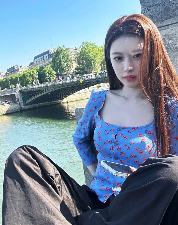 高允貞的這套，單品乍看好似很隨性，但其實細究的話，不難發現她隨手一來的搭配巧思。本身帶點法式甜感的藍色小碎花方領上衣，加上微貼身剪裁和鎖骨露出，既清新又有一點女人味，但同時，她還很聰明地用一條寬鬆黑色長褲去中和，瞬間把整體拉回偏率性、帶點慵懶的街頭感，甜而不膩。再加上幾乎沒有多餘配件、妝髮也走自然路線，讓重點回到版型和配色本身，整體就是一種不費力卻很有氛圍的時髦感。