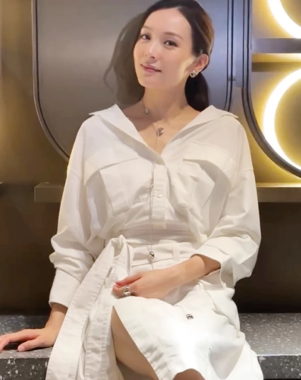 如果你想找一套應付正式場合或約會、卻又不想穿得太無聊的戰袍，看看李佳芯的這套全白襯衫式連身裙吧！看似簡單，心機全在細節裡。首先，故意不把領口扣死，微微往後拉成V領，露出漂亮的鎖骨鏈；第二步，一定要綁上同款式的寬版腰帶，抓出腰身與下半身的比例。這套衣服的精髓在於裙襬隱約的開衩，當你坐下時微微露腿，配上乾淨的低馬尾，那種由內而外散發的鬆弛感與高級知識份子氣質，真的比任何緊身衣都還要吸引人。