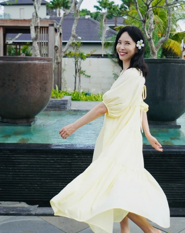 淡黃色澎袖長洋裝，自帶一種南法莊園的度假濾鏡，天心聰明地選擇了柔和的奶油黃，不僅比死白更具亮膚效果，寬鬆的傘擺與微澎袖型更能無痛遮肉、視覺減重。一般人想要複製這份不費力的仙氣，關鍵在於浪漫配飾與色彩的減法，日常穿搭時，不妨挑選低飽和度的初戀色系（如：淡藍、淺綠），並學天心在髮際側邊點綴一朵乾淨的白色花朵或度假感髮夾，腳下隨性踩一雙平底涼鞋或草編鞋，就能把甜美與慵懶拿捏得恰到好處，轉身就散發讓人怦然心動的少女氣息。