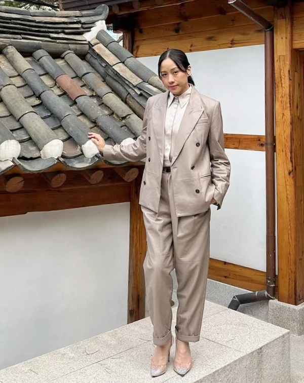日常想穿出這種高級的減齡感,秘訣就在於「同色系(Tone-on-Tone)」的延伸。我們可以換成一般人更好駕馭的燕麥色或淡鹽系西裝材質,上衣、外套到褲子都選同色系,視覺上非常拉長身型。記得學林嘉欣把褲管微微折起、露出一點點腳踝,再配上一雙帶有透明感的高跟鞋,那種不經意的俐落感就是優雅減齡的關鍵。