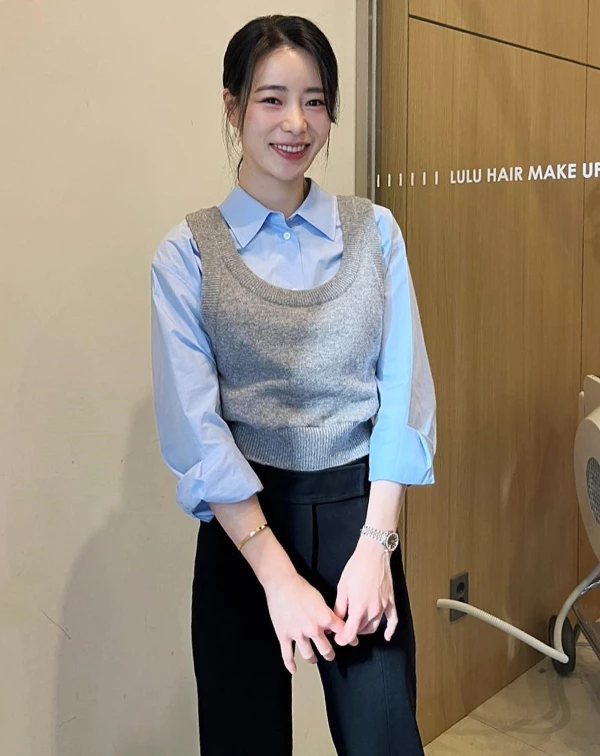 這套背心多層次穿搭中,林智妍展現了教科書級別的「職場精緻風」—她巧妙地以一件短版的灰色針織背心,疊穿在淺藍襯衫外,瞬間打破了單一襯衫的單調感,讓視覺效果更豐富。而在色調選擇上,比起鮮豔色彩,她更偏愛低飽和度的「莫蘭迪色系」,就像淺藍與灰色的組合,更能襯托出優雅的氣質。