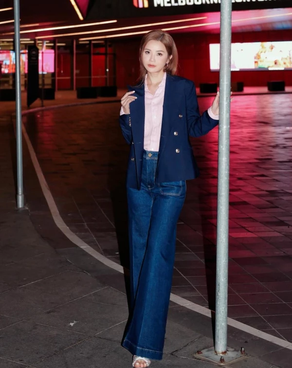 阿Sa將「職場專業」與「少女氣息」完美揉合，她以硬挺的深藍色雙排扣西裝建立知性氣場，內裡卻巧妙揉入一件柔粉色襯衫，利用色彩的溫度，化解了西裝的嚴肅感，讓整個人散發出溫柔卻堅定的幹練美。下半身捨棄了成套西裝褲，改以高腰復古寬款丹寧收尾，這種「上正式、下休閒」的混搭邏輯，為整體造型注入了一股隨性的時髦活力。