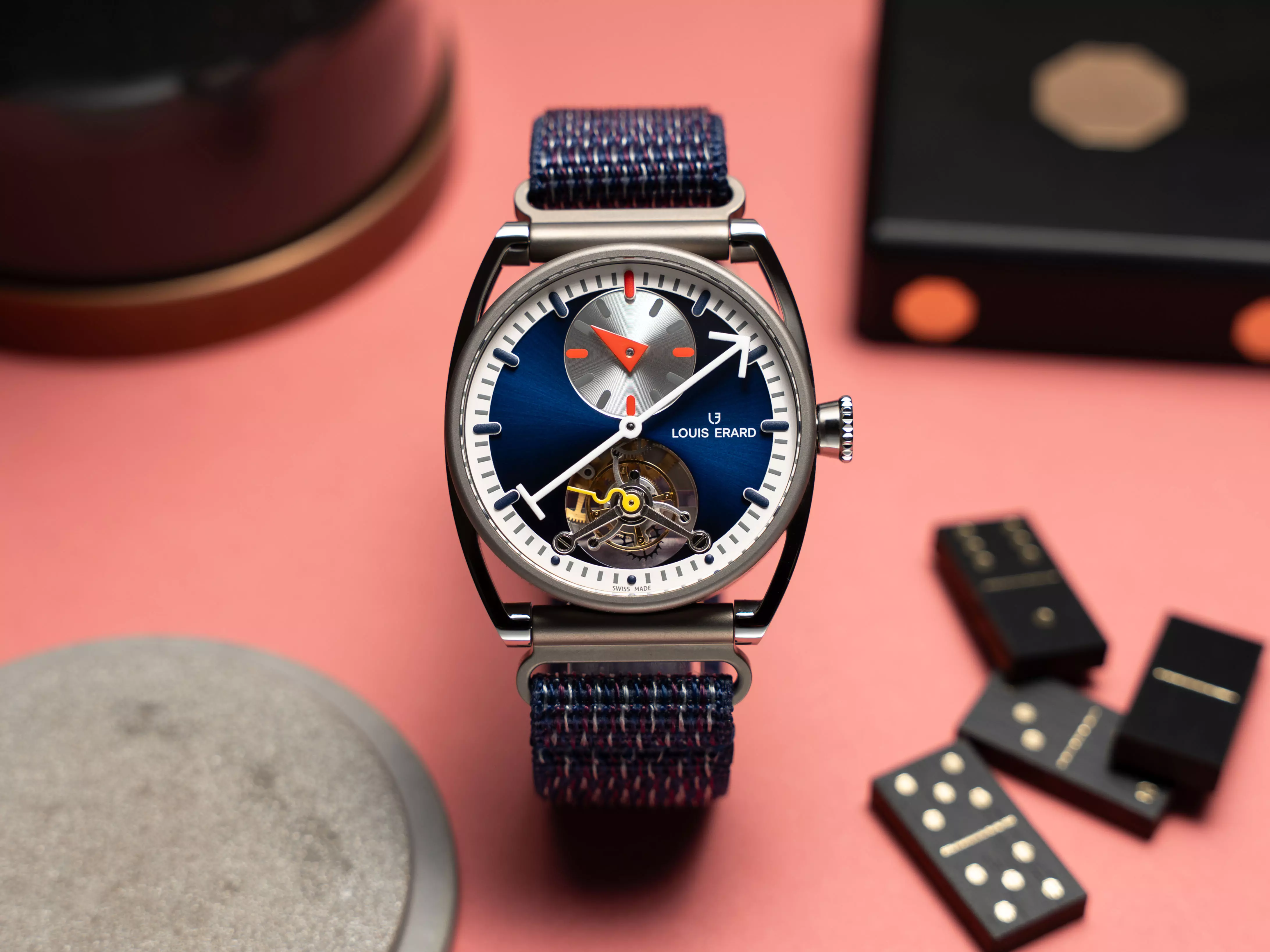 Régulateur Tourbillon Blue 將設計語言推進至更高層次,核心落在6點鐘位置的陀飛輪結構。由製錶師 Olivier Mory 專為 Louis Erard 開發的機芯,將橋板與齒輪運作直接呈現在視覺中心,使機械本身成為設計的一部分。時間顯示採用規範式佈局,中央分針搭配12點鐘小時盤,延續 Alain Silberstein 一貫的閱讀邏輯,也讓畫面保持清晰秩序。藍色放射紋面盤提供穩定背景,使複雜結構更易辨識。40mm 鈦金屬錶殼以微噴砂與拋光處理呈現細節,兼顧輕盈與質感,尼龍魔鬼氈錶帶則提升長時間配戴的舒適度。整體設計著重在結構、比例與運作的平衡,讓複雜功能與鮮明風格得以共存。此款聯名腕錶的年產量限制在50只,強調收藏屬性與工藝定位。