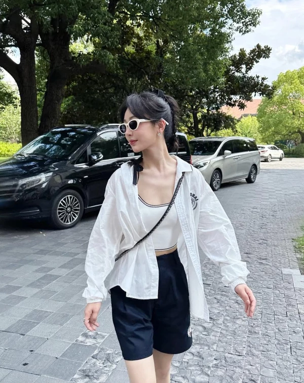 楊紫這套以白襯衫內搭白色吊帶的造型,展現出乾淨清新的夏日氛圍,輕薄材質,不僅透氣,也讓整體看起來更加輕盈自在。微微敞開的襯衫穿法,多了幾分隨性感,同時也能修飾身形,營造自然不刻意的時髦感。