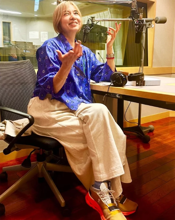 這套實在太Q了！山口智子在電台錄音室的穿搭，完全體現了什麼叫「玩心不減」。尤其是我一眼相中的鞋子配色，簡直是這整套穿搭的靈魂單品！我周遭很多同齡女性們都不太敢穿亮色，因怕太招搖。但其實不如學學山口智子，下半身用淡色系的寬褲或裙子來中和，讓視覺焦點集中在臉部附近的藍色，氣色會看起來非常好。最後再配一雙顏色大膽、具有設計感的機能運動鞋，不僅能與上衣呼應色系，還能傳遞出一種「我隨時準備好迎接新事物」的生活態度，這才是最無敵的減齡心法。