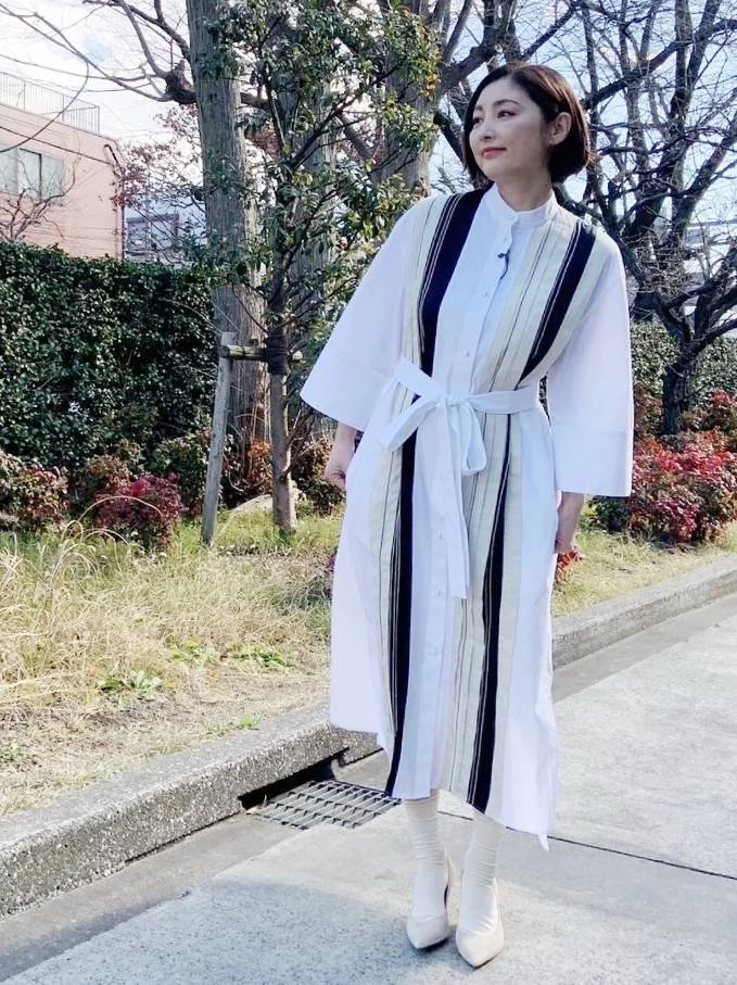 這張穿搭照中，展示了常盤貴子對層次穿搭的掌握。這款白色襯衫洋裝，利用不同材質的布料拼接，創造出豐富的視覺感。不僅打破單調，也巧妙地修飾了身形。腰間的束帶設計，更是點睛之筆，抓出腰線，展現女性柔美曲線。在穿著素色洋裝時，不妨尋找擁有拼接或特色剪裁的款式。並可利用腰帶、絲巾...等配件，讓整體造型也能創造出層次感喔。