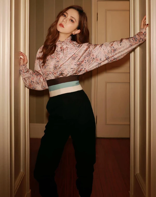向來敢穿、敢混搭的鄧紫棋，這回罕見演繹出一種「復古宮廷叛逆感」。她以淡粉色碎花高領絲緞上衣為主角，細緻的印花與澎鬆袖口勾勒出濃厚的歐式浪漫氣息，視覺份量十足卻不顯累贅。
