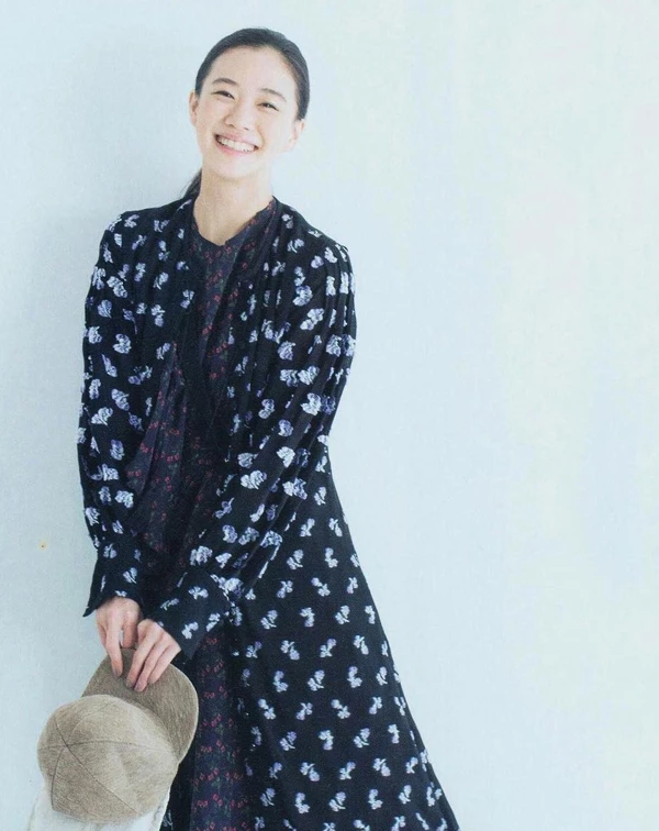 蒼井優在這一套利用了黑底印花長版罩衫，內搭同色系的細碎花洋裝，手中則拿著一頂大地色的燈芯絨棒球帽。透過長、短層次的堆疊與率性帽款的加入，將可能流於老氣的碎花穿出了古著少女的調皮感。