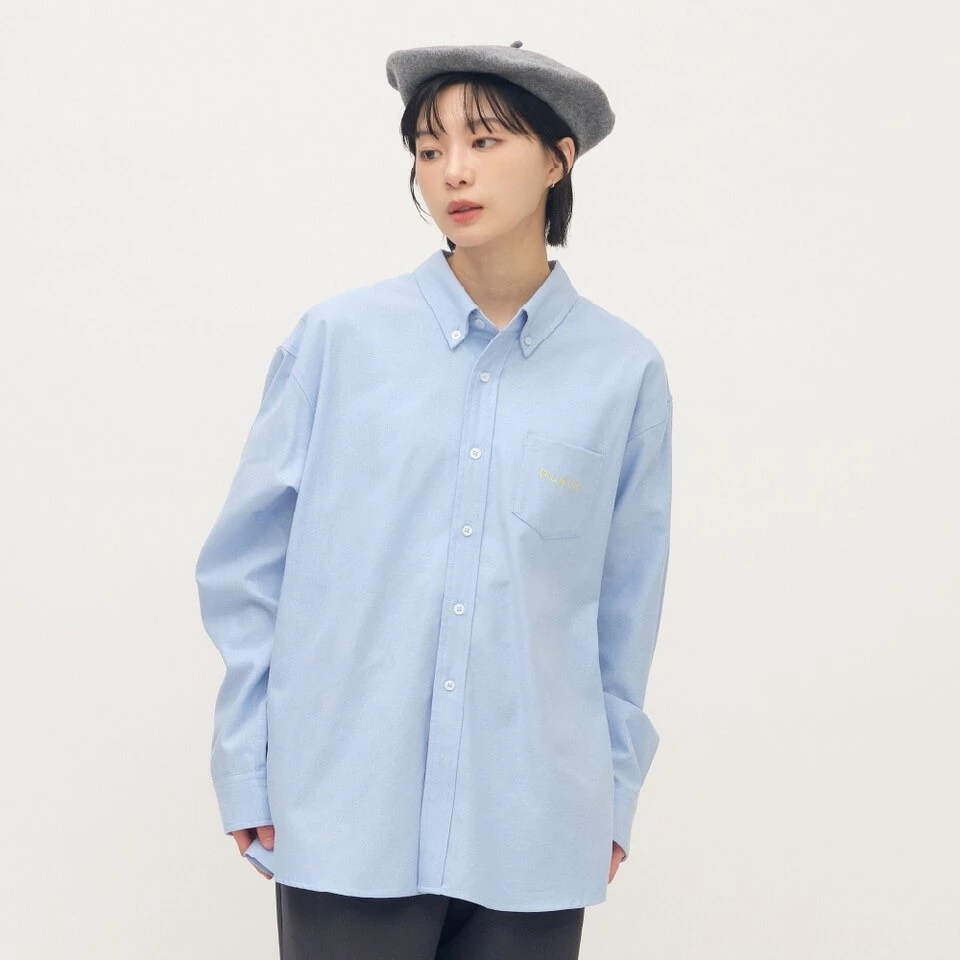 plain-me PLAIN刺繡經典條紋牛津襯衫藍條紋，經典牛津材質、胸前口袋與弧線下襬修飾身形，鬆身版型，售價NT$1,881。