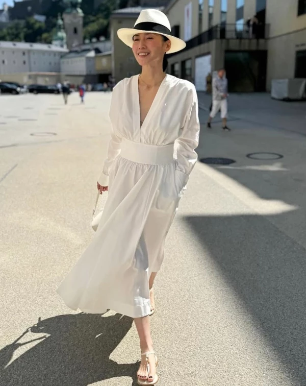中谷美紀的這套大V領洋裝穿搭告訴我們：「經典的純白，就能讓你重回少女般的輕盈。」這身減齡穿搭相當容易效法，不要覺得白色顯胖，快去買一條剪裁精良的連身裙，其身形修飾的秘訣就在於「一定要有腰身設計」！像中谷美紀這種寬束腰設計最理想；然後，請告別球鞋或高跟鞋，搭一雙她腳上那種隨性、有設計感的平底涼鞋或穆勒鞋，哪怕在台灣街頭，也能穿出如在歐洲度假的鬆弛感。