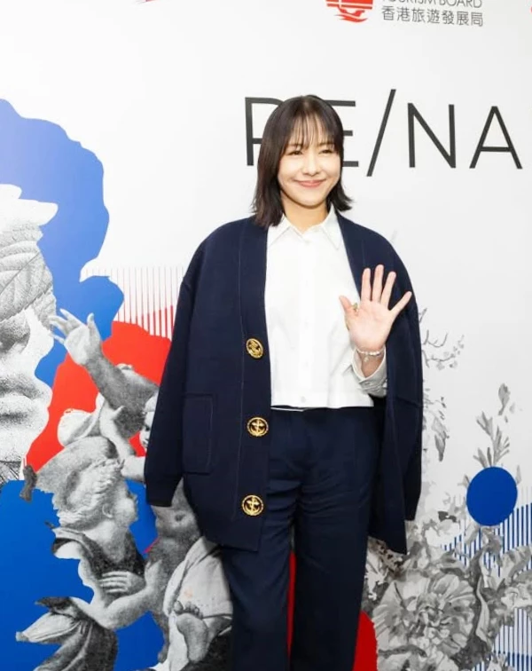 林嘉欣出席活動時,沒有選死板板的硬挺西裝,而是穿了一件帶有金釦設計的海軍藍針織外套,內搭乾淨的白襯衫與同色落地寬褲。這種用軟料針織取代正裝的穿法,既體面又多了一份溫柔的書捲氣。