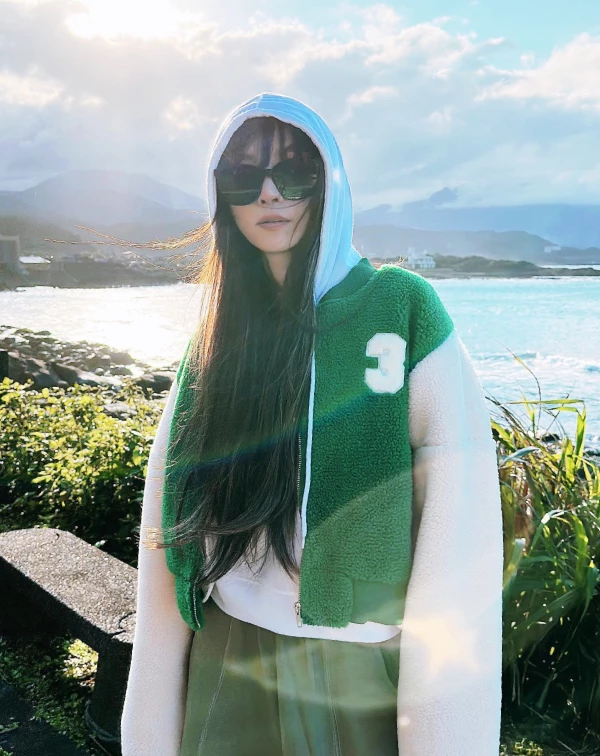 這套與海景完美融合的運動街頭造型，另外展現出謝金燕隨性又充滿氛圍感的穿搭主見，極具魅力。其核心就在於「舒適機能與疊穿美學」，透過具層次感的短版連帽外套，不僅讓上半身比例顯得輕盈，那份慵懶的連帽設計更是“減齡神器”，搭配寬鬆長褲與厚實運動鞋，完美演繹了不費力的鬆弛感。