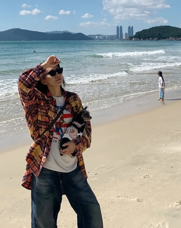 覺得單穿亮色T恤不自在?不如就學學金瑞亨的搭法,外搭一件格紋襯衫當薄外套,整體造型層次分明,既有美式復古的街頭感,又兼具防曬、修飾手臂的效果,完美融入了海邊輕鬆、自在的度假氛圍。