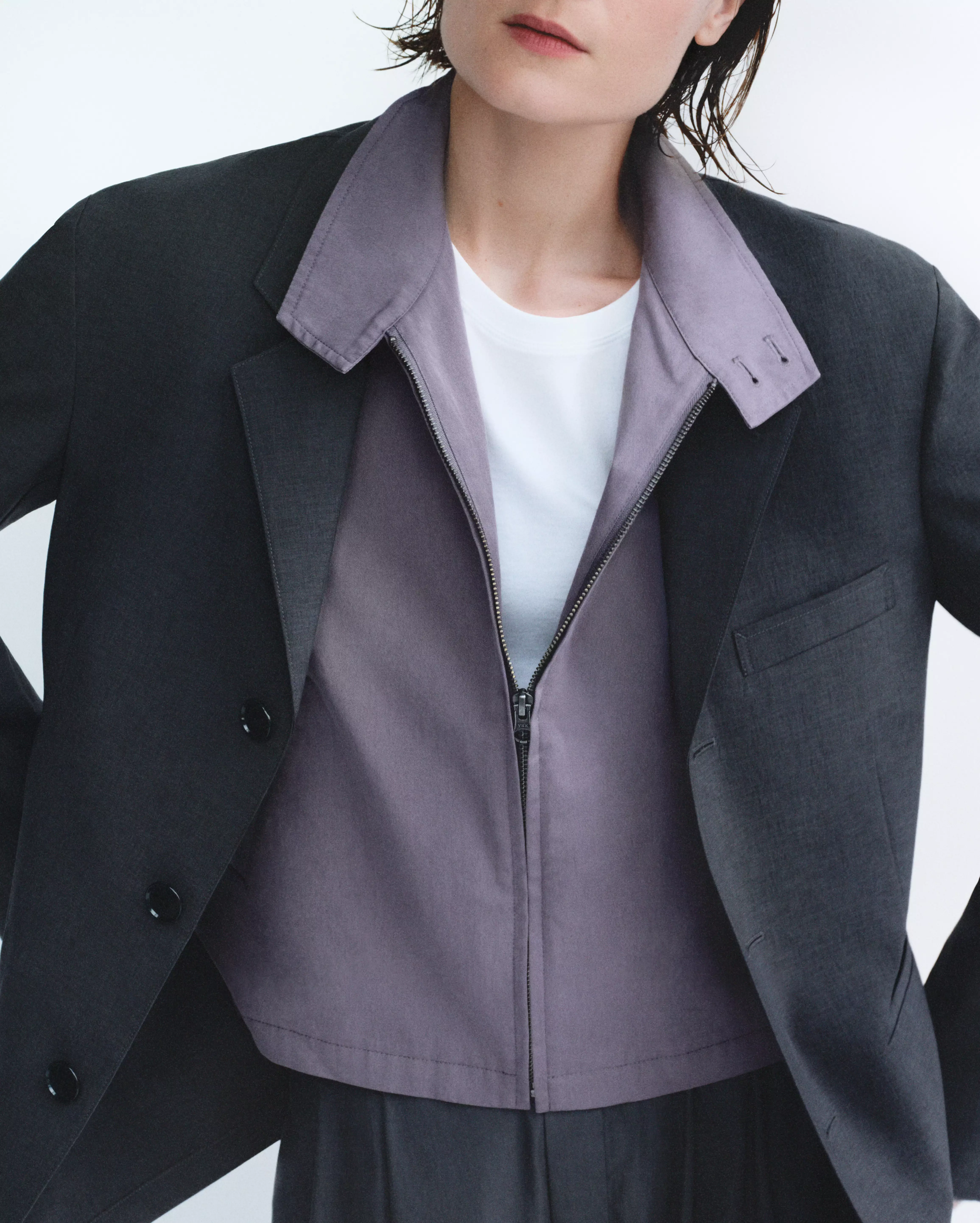 短版布勞森外套向來是 Uniqlo U 的代表性輪廓之一，本季版本以棉質尼龍斜紋材質打造，保留挺度與輕盈感之間的平衡。整體採無內裡設計，使外套在春夏氣候下依然保持舒適透氣。短版箱型剪裁搭配俐落肩線，穿起來既有結構感，也不會顯得過於正式。細節設計同樣延續巴黎設計團隊一貫的克制美學，金屬拉鍊開合為整體增加俐落質感，領口的雙鈕釦則帶出略帶工裝味的立體輪廓。背面加入鬆緊設計，讓外套在行走與活動時呈現自然弧度。深棕色、灰藕紫與象牙白三種配色，都屬於低飽和色系，非常容易融入日常衣櫃。搭配高腰褲或寬版牛仔褲，都能輕鬆建立簡潔有力的春季造型。