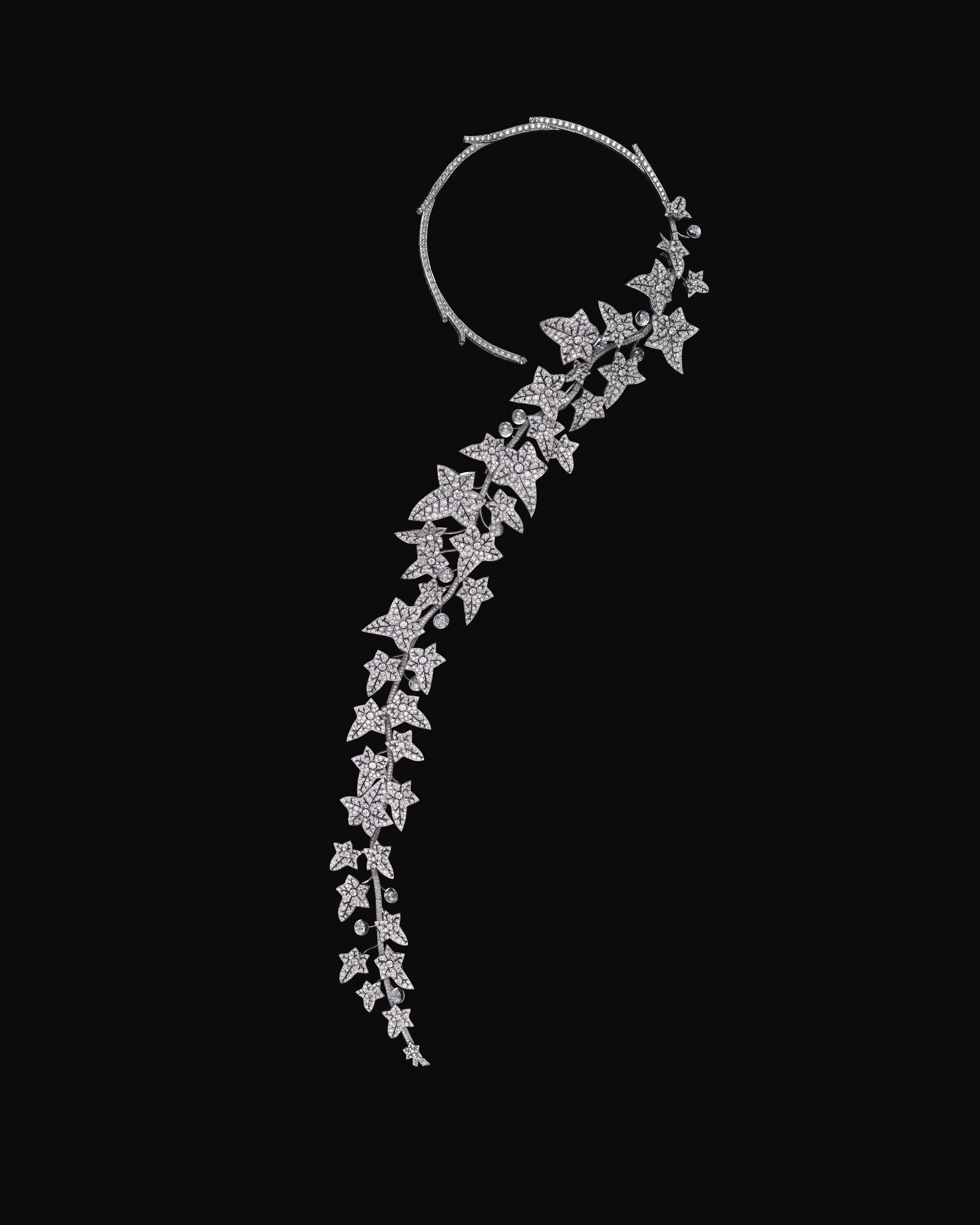 在一個習慣將自然「美化」的年代,寶詩龍先生卻偏愛未經修飾的生命狀態。當別人追捧玫瑰與百合,他鍾愛的則是不按牌理生長的常春藤。對他而言,自然之美並不在於被修剪後的完美輪廓,而在於其真實、野性且持續生長的狀態。今年的收尾作品〈The Untamed〉,正是這份觀點的具體呈現,將經典問號項鍊的輪廓延伸至近乎人體藝術的比例,鑲嵌鑽石的藤蔓沿著身體曲線自然垂落,隨動作擺盪,彷彿正在生長。整體結構可拆卸、可轉換,透過多重關節系統,回應不同佩戴方式與身體姿態。水晶雕琢的果實、逐片製作的葉片,以及輕顫結構所帶來的細微律動,使作品不再只是對自然的描寫,而是近乎模擬生命本身的節奏與呼吸。它野性卻精準,證明自由與工藝從來不是對立面,而是可以相互成就的核心價值。