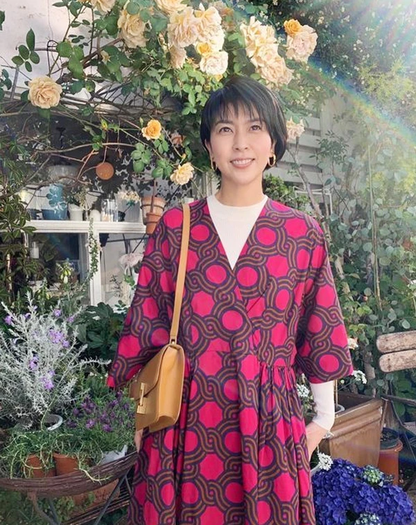 松隆子的這套,其實很容易讓人多看幾眼。桃紅色幾何印花洋裝,本身已經很有存在感,但她在裡面多搭了一件白色高領針織後,整體感覺,就立刻變得柔和很多,也讓亮色不會顯得太過強勢。再加上焦糖色皮革肩背包和簡單的金色耳環,整體配色看起來很有春夏感,帶點成熟感之餘,又不會顯老。